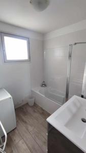 La salle de bains blanche est pourvue d'une douche et d'un lavabo. dans l'établissement Agréable T2 Bis Au calme proche centre-ville et plages, à Sanary-sur-Mer