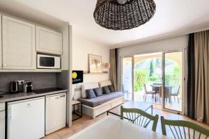 eine Küche und ein Wohnzimmer mit einem Sofa und einem Tisch in der Unterkunft Village Pont Royal en Provence - maeva Home - Studio 5 personnes - Sélectio 824 in Mallemort