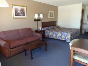 Habitación de hotel con sofá y cama en National 9 Inn en Garden City