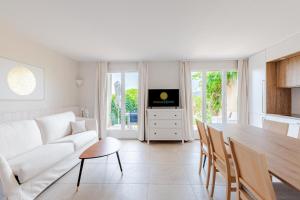 a living room with a white couch and a table at Les maisons et villas de Pont Royal en Provence - maeva Home - Maison 4 piè 124 in Mallemort