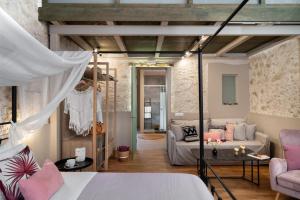 a bedroom with a bed and a living room at Mansio Boutique Hotel in Rethymno Town