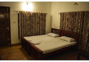 瓦亚纳德Spice Fields Cottage - 3 Bedroom - Wayanad的床上床,带窗帘和床罩