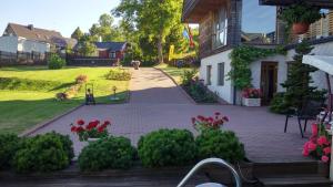 a house with a garden with flowers and a playground at Prie Galvės in Trakai