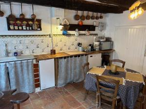 cocina con mesa, mesa y sillas en Maison dans la magnifique village de Montjoi, en Monjoi