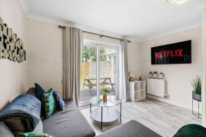 uma sala de estar com um sofá e uma mesa em 4 Bedroom Cambridgeshire Home em Cambourne