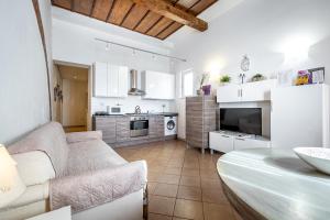 sala de estar con sofá y cocina en Roommo Beccaria, en Florencia