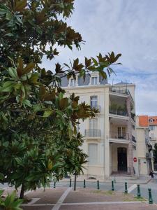 - un bâtiment blanc avec un balcon et un arbre dans l'établissement Beautiful and bright 1st Floor Flat with large Terrace - Biarritz City Center, à Biarritz