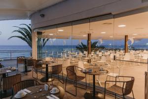 a restaurant with tables and chairs with the ocean in the background at Don Gregory by Dunas - Adults Only in San Agustin +37 photos