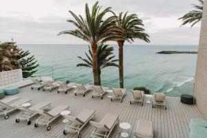 una terraza con sillas y vistas al océano. en Don Gregory by Dunas - Adults Only, en San Agustín
