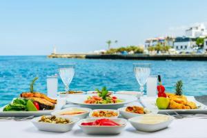 凱里尼亞的住宿－DOME Hotel & Casino at Central Kyrenia，餐桌,带食物盘和水杯
