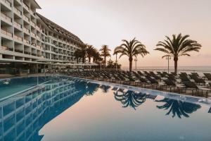 a hotel swimming pool with chairs and palm trees at Don Gregory by Dunas - Adults Only in San Agustin