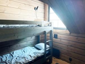 a bunk bed in a wooden room with a window at Fantastic Mountain Cabin with Sauna in Idre in Idre
