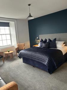 THE LORD NELSON HOTEL في بيمبروكشاير: غرفة نوم بسرير كبير بجدار ازرق
