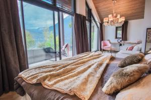 a bedroom with a large bed with a large window at Villa Caroline, Lac d'Annecy in Duingt