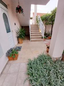 a porch of a house with potted plants and stairs at Apartments Joy in Cavtat