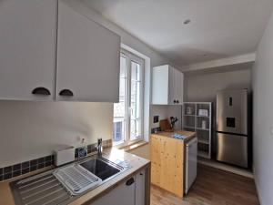 La cuisine est équipée d'un évier et d'un réfrigérateur. dans l'établissement Bleu azur 2 chambres, climatisation, parking, à Villeneuve-lès-Avignon
