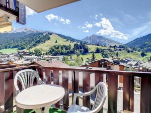 a table and chairs on a balcony with a view at La Résidence RS0224 Bat.2 in La Clusaz