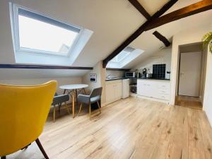 a kitchen with a table and chairs in a room at Casa Balzac – T2 in Angers
