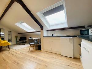 an attic kitchen with a large skylight and a kitchen with at Casa Balzac – T2 in Angers +5 photos