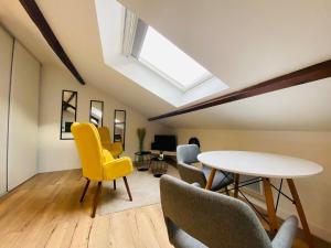 a room with a table and chairs and a skylight at Casa Balzac – T2 in Angers