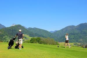 een man en een vrouw die golfen met een hond bij Résidence Anges - Studio pour 4 Personnes 814 in Montgenèvre