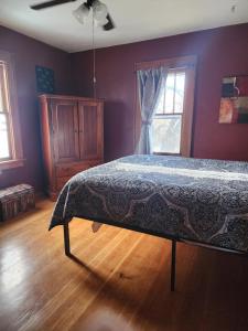 Schlafzimmer mit einem Bett und einem Fenster in der Unterkunft Spacious Farmhouse with Pond in Augusta