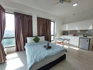 a bedroom with a large bed and a kitchen at Inspired Homes @ PJ The Grand Sofo in Petaling Jaya