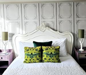 a bedroom with a white bed with yellow pillows at Burlington Berties in Sheringham