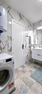 La salle de bains est pourvue d'un lave-linge et d'un lavabo. dans l'établissement National Trust Beach Apartment, à Santiago del Teide