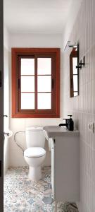La salle de bains est pourvue de toilettes, d'un lavabo et d'une fenêtre. dans l'établissement National Trust Beach Apartment, à Santiago del Teide
