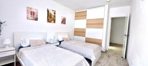 une chambre à l'hôpital avec deux lits et une fenêtre dans l'établissement National Trust Beach Apartment, à Santiago del Teide