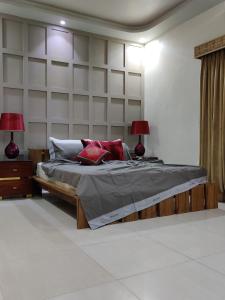 a bedroom with a bed with two lamps and a wall at Supreme Villa Block 6 Gulshan-e-iqbal Auto Generator in Karachi