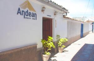 um edifício branco com vasos de plantas à sua frente em Hotel Andean Host Inn em Cusco