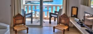 a living room with two chairs and a view of a balcony at Apartments Casa Sul Mare in Pisak