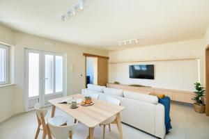 ein Wohnzimmer mit einem weißen Sofa und einem Tisch in der Unterkunft Luxe Retreat in Lapad - Seaside in Dubrovnik