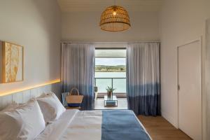 a bedroom with a bed and a large window at Hotel Aretê in Búzios +102 photos