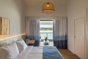 a bedroom with a bed and a large window at Hotel Aretê in Búzios