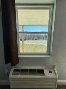 uma janela por cima de um ar condicionado em frente a uma janela em Budget Inn em Thomasville