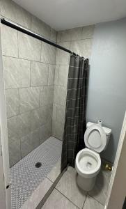 uma casa de banho com um chuveiro, um WC e uma cortina de chuveiro. em Budget Inn em Thomasville