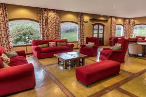 sala de estar con muebles de color rojo y mesa en Kau Yatún Hotel Boutique en El Calafate
