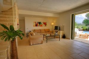 ein Wohnzimmer mit Sofa und Tisch in der Unterkunft Villa Telina Ideales Resort in Kefalonia