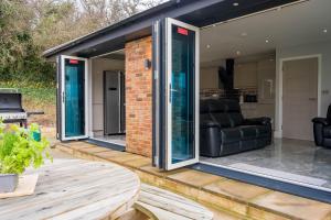 a conservatory with sliding glass doors on a patio at Pure relaxation at it's finest, offering moments of harmony and tranquillity - Sauna & Hot tub in Shanklin