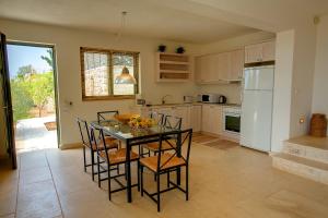 a kitchen with a table with chairs and a refrigerator at Villa Asterias Ideales Resort in Kefallonia