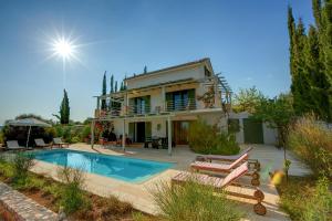 une villa avec une piscine et une maison dans l'établissement Villa Asterias Ideales Resort, à Céphalonie
