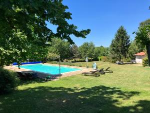 una piscina en un patio con mesas de picnic en Puyleger, en Saint-Privat-des-Prés