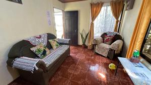 een woonkamer met een bank en 2 stoelen bij The Corner House in Tortuguero