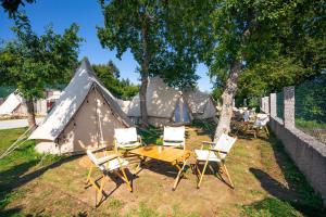 a table and chairs in front of a tent at Kampaoh Pinténs in Aldán