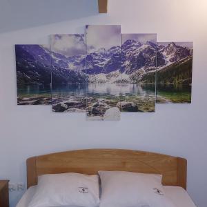 a bedroom with snow capped mountains on the wall at Apartamenty Pod Skałką in Szaflary