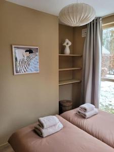 a bedroom with two beds with towels on them at Japandi Wellness met hottub & sauna in Ewijk