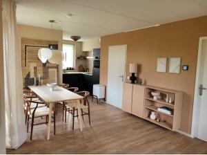 a dining room and kitchen with a table and chairs at Japandi Wellness met hottub & sauna in Ewijk